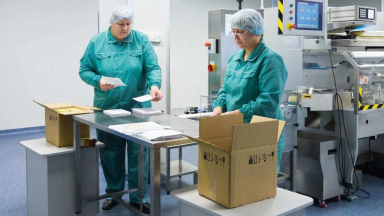 Two workers in a Pharmaceutical company managing clinical supplies