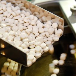 Closeup of pharmaceutical medicine tablet pill production in the rails